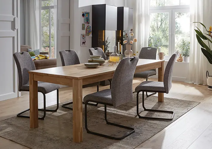 Holztisch mit sechs grauen Stühlen, Geschirr, Sideboard und Kamin